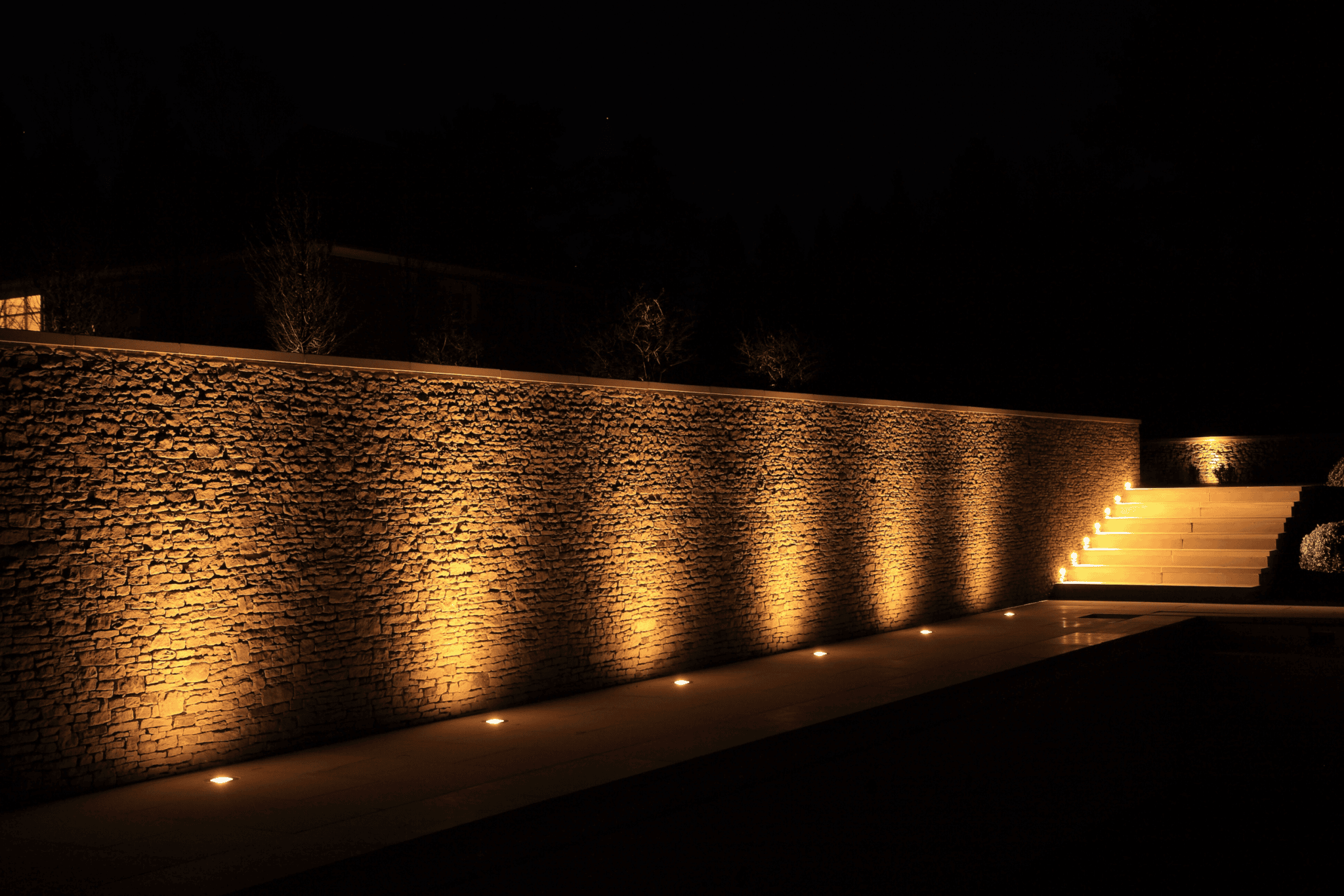 Wall lights leading to lit up stairs